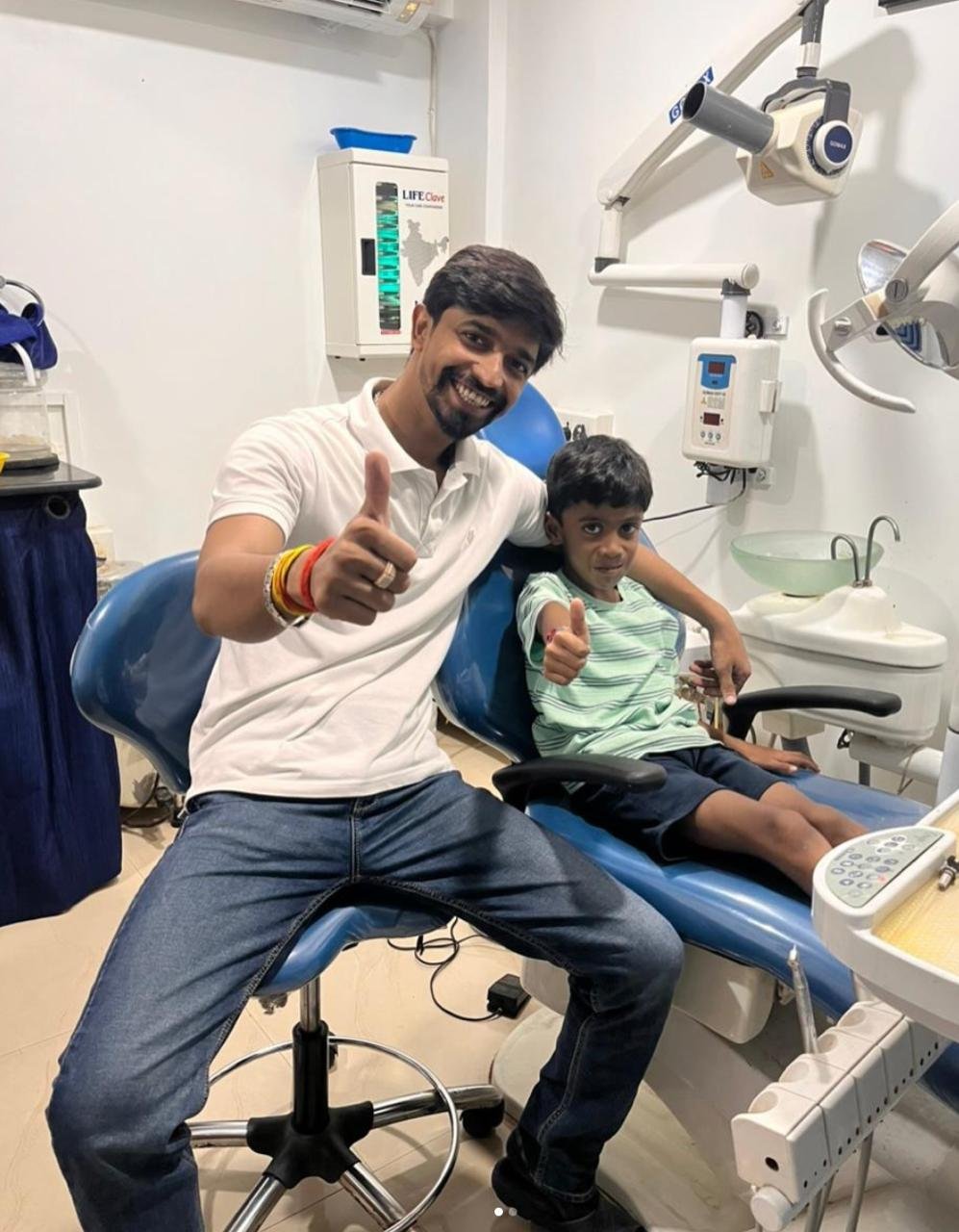 Smiling child patient with thumbs up alongside Dr. Anshul Sahu